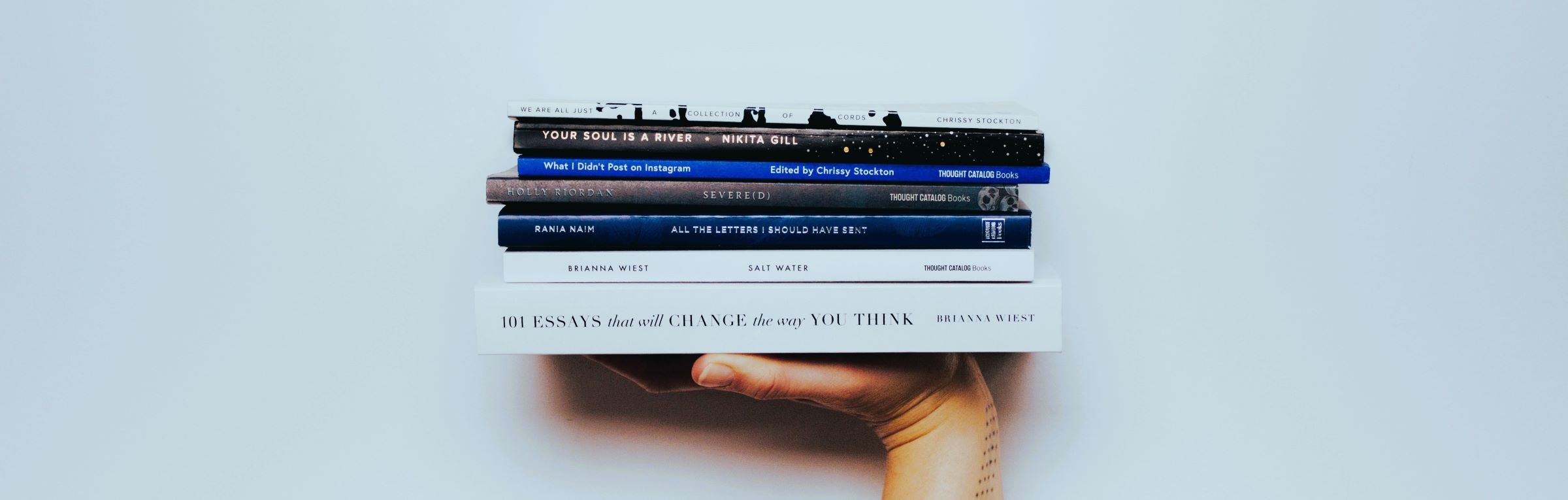 hand holding a stack of books